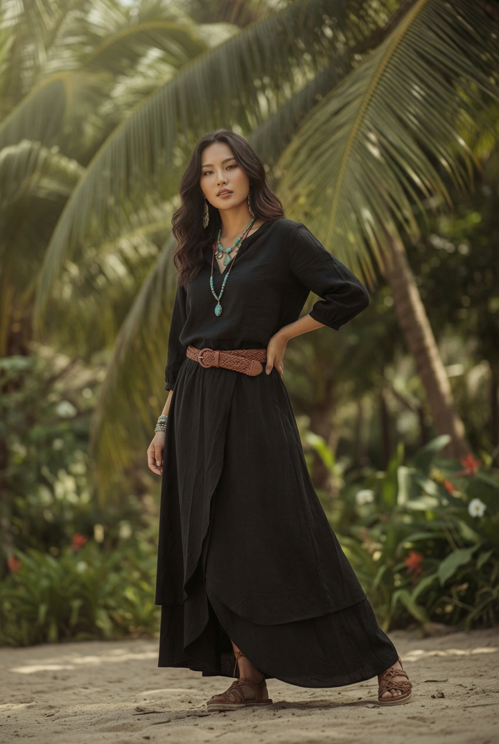 Woman in a black dress standing in a tropical setting with palm trees.