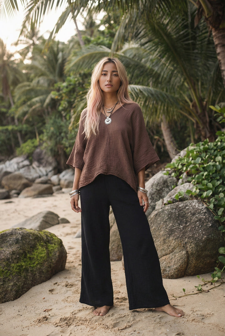 Woman standing on a beach with palm trees in the background